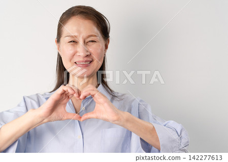 一位身著休閒服的老婦人站著——一張生活方式照片。 一位身著休閒服的老婦人站著——一張生活方式照片。 142277613