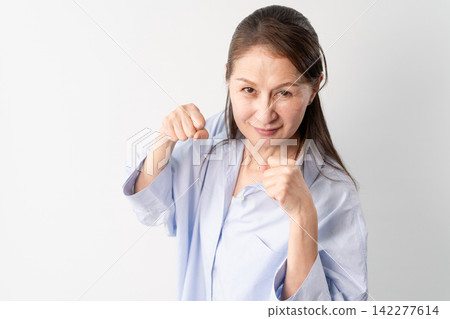 一位身著休閒服的老婦人站著——一張生活方式照片。 一位身著休閒服的老婦人站著——一張生活方式照片。 142277614