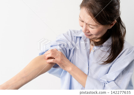 A senior woman in casual clothes standing – a lifestyle image. A senior woman in casual clothes standing – a lifestyle image. 142277635