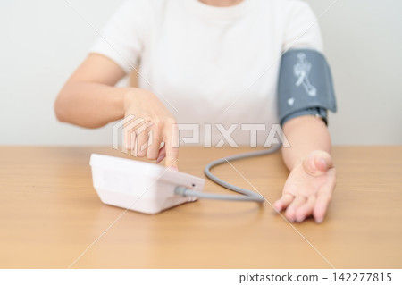 woman checking Blood pressure by Blood pressure monitor with Cuff. Systolic, SYS, Diastolic, DIA, Pulse, Hypertension, Hypotension, Heart rate, Cardiovascular Disease and May World hypertension day woman checking Blood pressure by Blood pressure monitor with Cuff. Systolic, SYS, Diastolic, DIA, Pulse, Hypertension, Hypotension, Heart rate, Cardiovascular Disease and May World hypertension day 142277815