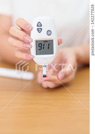 Hand checking Diabetes or Blood glucose self testing by digital blood glucose meter with lancet pen. high blood sugar level, World Diabetes Day, Glycemia, Hypoglycemia, Hyperglycemia and insulin Hand checking Diabetes or Blood glucose self testing by digital blood glucose meter with lancet pen. high blood sugar level, World Diabetes Day, Glycemia, Hypoglycemia, Hyperglycemia and insulin 142277826