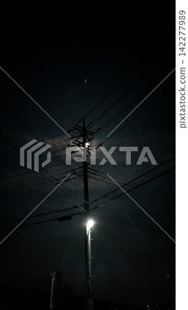 透過雲層的縫隙,可以看到月亮和一根電線桿。 透過雲層的縫隙,可以看到月亮和一根電線桿。 142277989