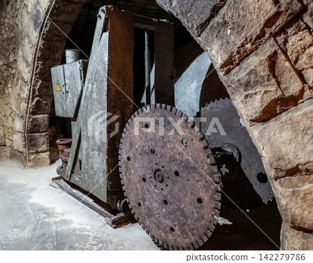 Vintage stone cutting machine inside underground wine cellars tunnel Vintage stone cutting machine inside underground wine cellars tunnel 142279786