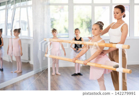 Little ballerinas together with choreography teacher in grand batman pose learn to dance ballet Little ballerinas together with choreography teacher in grand batman pose learn to dance ballet 142279991