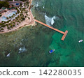 Aerial view of sandy beach with wooden pier leading over the Caribbean sea 142280035