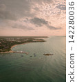 Panorama of sandy beach with wooden pier leading over Caribbean sea at sunset 142280036