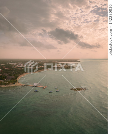 Panorama of sandy beach with wooden pier leading over Caribbean sea at sunset Panorama of sandy beach with wooden pier leading over Caribbean sea at sunset 142280036