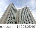 Hong Kong Towering residential building with many windows against cloudy sky Hong Kong Towering residential building with many windows against cloudy sky 142280340