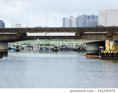 A bridge over the Keihin Canal in Shinagawa, Tokyo, and the surrounding cityscape. A bridge over the Keihin Canal in Shinagawa, Tokyo, and the surrounding cityscape. 142280974