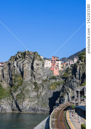 Manarola in Italy with railway curve rising toward the village under a clear blue sky Manarola in Italy with railway curve rising toward the village under a clear blue sky 142281580