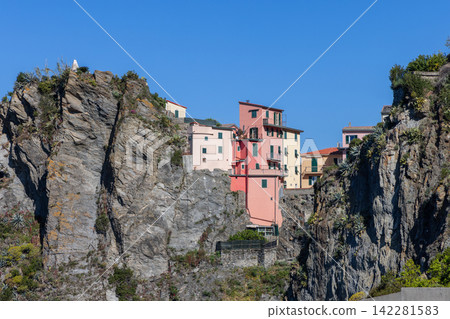 Manarola within Liguria, Italy with central pink building enclosed by rock Manarola within Liguria, Italy with central pink building enclosed by rock 142281583