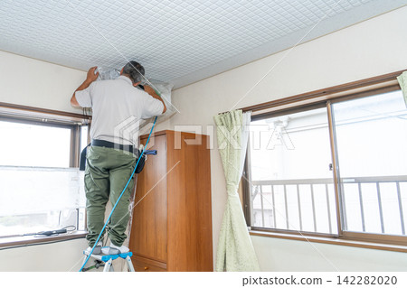 Air conditioner cleaning; a man from the air conditioner maintenance company. Air conditioner cleaning; a man from the air conditioner maintenance company. 142282020
