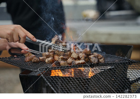 Flipping Diced Pork On Grill Flipping Diced Pork On Grill 142282373