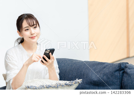 使用智慧型手機的女人 使用智慧型手機的女人 142283306