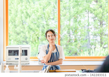 A woman thinking in the kitchen. Cooking, recipes, menus, nutritionists, worries, questions, anxieties, concerns, dissatisfaction, housework, housewives, troubles A woman thinking in the kitchen. Cooking, recipes, menus, nutritionists, worries, questions, anxieties, concerns, dissatisfaction, housework, housewives, troubles 142283311