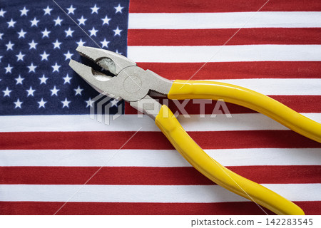 American flag and a plier, top view. Hand tools with Flag of the United States of America American flag and a plier, top view. Hand tools with Flag of the United States of America 142283545