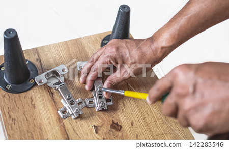Furniture assembly. Work tool and components. Male Carpenter at work Furniture assembly. Work tool and components. Male Carpenter at work 142283546