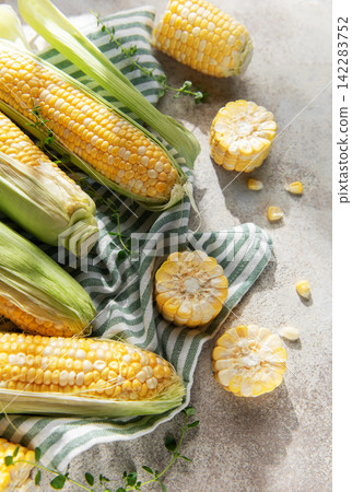 Fresh organic corn cobs and kernels on rustic background Fresh organic corn cobs and kernels on rustic background 142283752