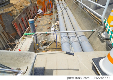A scene of civil engineering work being carried out using large drainage pipes in an irrigation canal and retaining wall. A scene of civil engineering work being carried out using large drainage pipes in an irrigation canal and retaining wall. 142284432