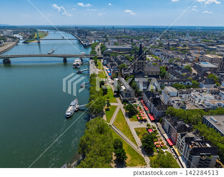High angle wide horizontal aerial drone photograph of Great St Martin Church, Rhine riverfront, waterfront promenade, and city skyline in Cologne, North Rhine-Westphalia, Germany, Central Europe High angle wide horizontal aerial drone photograph of Great St Martin Church, Rhine riverfront, waterfront promenade, and city skyline in Cologne, North Rhine-Westphalia, Germany, Central Europe 142284513