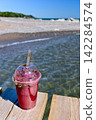 Bees swarming around a pink smoothie 142284574