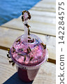Bees swarming around a pink smoothie 142284575