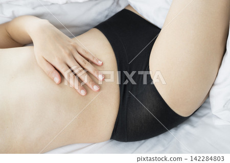 Hand Resting on Bare Abdomen in Bed Hand Resting on Bare Abdomen in Bed 142284803