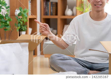 一位年輕人正在收拾行李準備搬家。 142285167