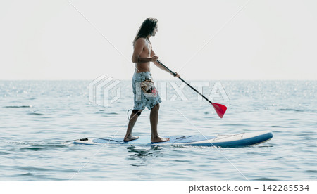 Paddleboarding, Water Sports, Man on Paddleboard Enjoying the Calm Sea Paddleboarding, Water Sports, Man on Paddleboard Enjoying the Calm Sea 142285534