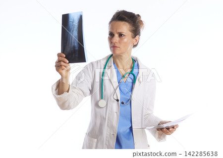Focused Female Doctor Examining Leg X-ray and Medical Records Focused Female Doctor Examining Leg X-ray and Medical Records 142285638