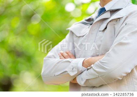 A man in work clothes, fresh greenery, close up. A man in work clothes, fresh greenery, close up. 142285736