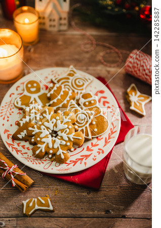 Holiday background. Christmas gingerbread cookies in different shapes in a plate Holiday background. Christmas gingerbread cookies in different shapes in a plate 142285887