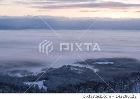 清晨,厚厚的雲層完全遮蔽了白雪皚皚的森林。 清晨,厚厚的雲層完全遮蔽了白雪皚皚的森林。 142286122
