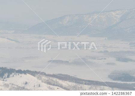 Snow-covered plains and mountain ranges shrouded in mist. Snow-covered plains and mountain ranges shrouded in mist. 142286367