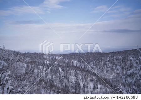 A slope covered in rime ice and a plain shrouded in mist in the distance. A slope covered in rime ice and a plain shrouded in mist in the distance. 142286688