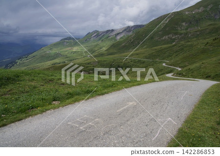 山路蜿蜒穿過綠色的山坡。 山路蜿蜒穿過綠色的山坡。 142286853
