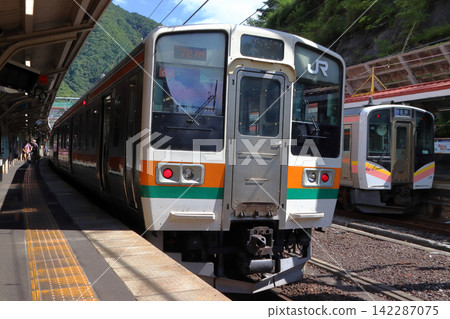 Joetsu Line 211 series and E129 series trains stopped at Minakami Station Joetsu Line 211 series and E129 series trains stopped at Minakami Station 142287075