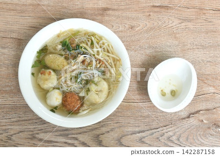 boiled rice vermicelli noodles fish and shrimp meatball couple dumping with bean sprout dressing chop pork in clear soup on bowl dipping spicy chili vinegar sauce boiled rice vermicelli noodles fish and shrimp meatball couple dumping with bean sprout dressing chop pork in clear soup on bowl dipping spicy chili vinegar sauce 142287158