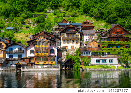 Hallstatt, Austria: A beautiful World Heritage village nestled in the foothills of lush green mountains. Hallstatt, Austria: A beautiful World Heritage village nestled in the foothills of lush green mountains. 142287277