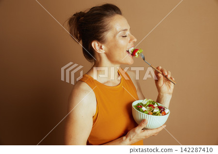 Mindful Woman Enjoys Healthy Yellow Tank Top Salad Mindful Woman Enjoys Healthy Yellow Tank Top Salad 142287410