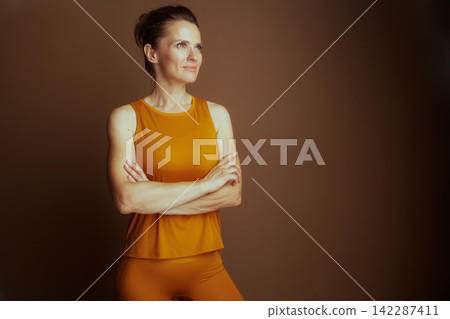 Confident Woman in Mustard Yellow Activewear Confident Woman in Mustard Yellow Activewear 142287411