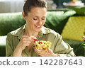 Woman Picking a Red Grape from a Fresh Fruit Bowl 142287643
