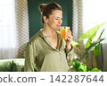 Woman Enjoying the Aroma of Fresh Orange Juice 142287644