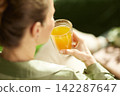 Woman Enjoying Fresh Orange Juice at Home 142287647