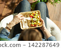 Overhead View of Woman Eating Fresh Fruit Salad 142287649