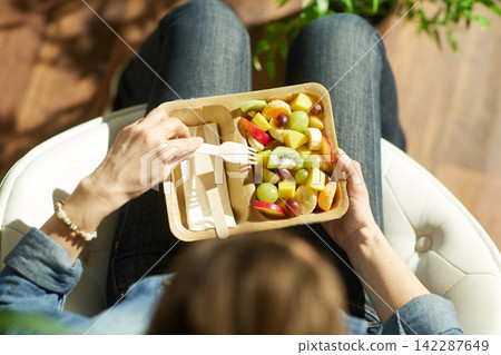 Overhead View of Woman Eating Fresh Fruit Salad Overhead View of Woman Eating Fresh Fruit Salad 142287649