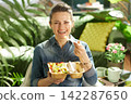 Cheerful Woman Enjoying Organic Fruit Salad Indoors 142287650