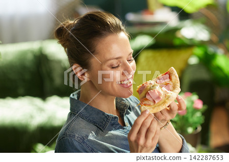 Happy Woman Smelling Fresh Pizza Slice at Home Happy Woman Smelling Fresh Pizza Slice at Home 142287653