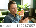 Relaxed Lunch Break with Pizza and Phone 142287657