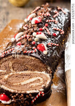 Christmas chocolate yule log cake with festive decorations Christmas chocolate yule log cake with festive decorations 142287751